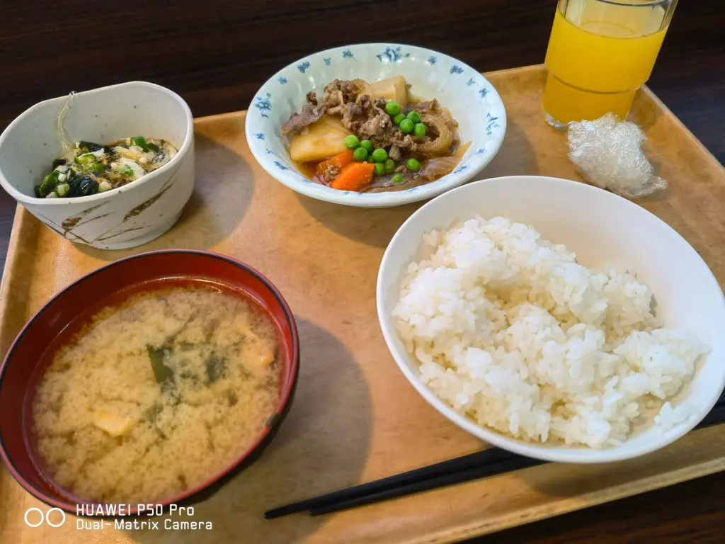学生寮ドーミーの朝食和食メニュー。ご飯、味噌汁、肉じゃが、サラダが並ぶ定食