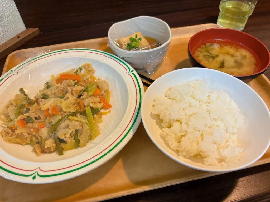 学生寮ドーミーの夕食メニュー。野菜炒め、油揚げ、ご飯、味噌汁の定食