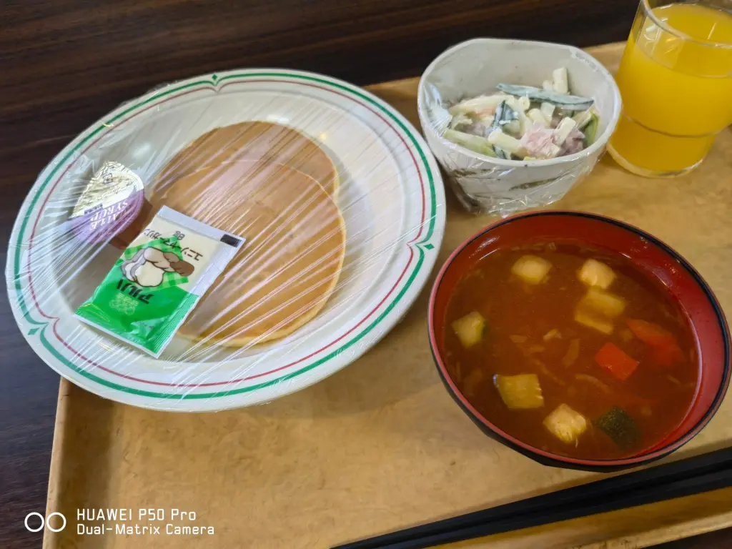 学生寮ドーミーの朝食洋食メニュー。ホットケーキ、スープ、サラダ、ジュースのセット